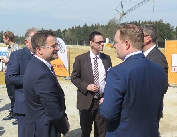Fünf Männer im Gespräch auf einer Baustelle
