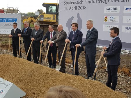 Acht Männer mit Schaufeln in der Hand beim Spatenstich